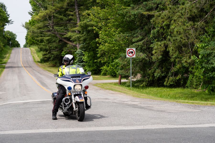 An officer on a motorcyle looks at oncoming traffic before making a turn