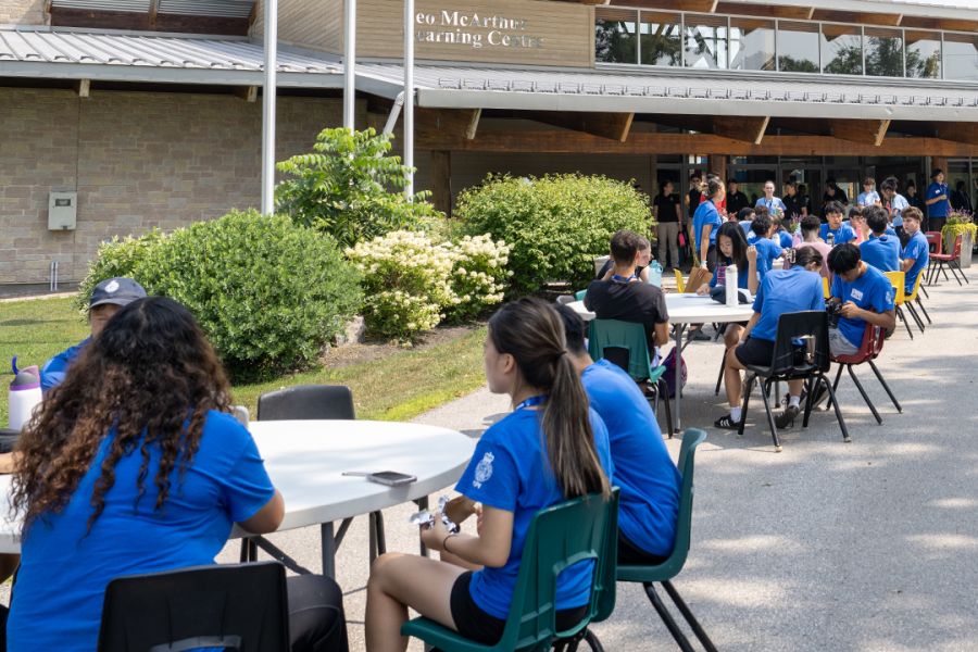 A group of people in blue t-shirts around tables