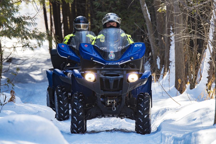 YRP officers drive two ATVs down a snowy path