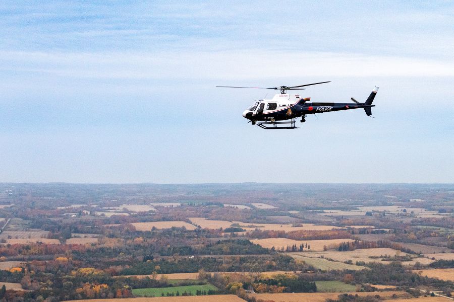 A helicopter flies over a rural landscape