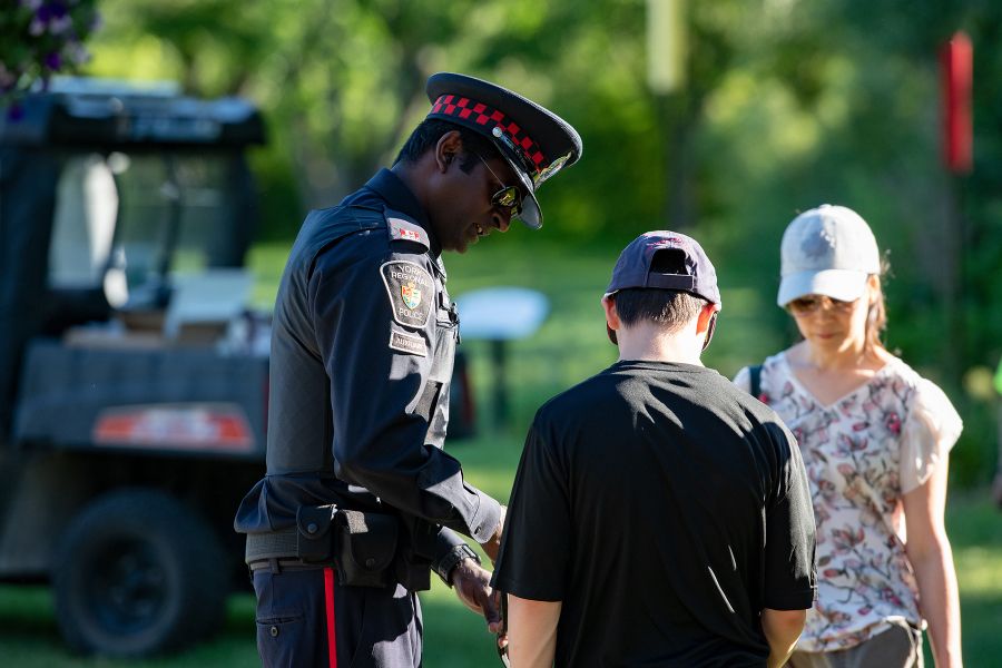 An officer speaks with a woman and her son