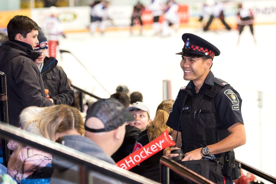 A man in a uniform smiles inside an arena