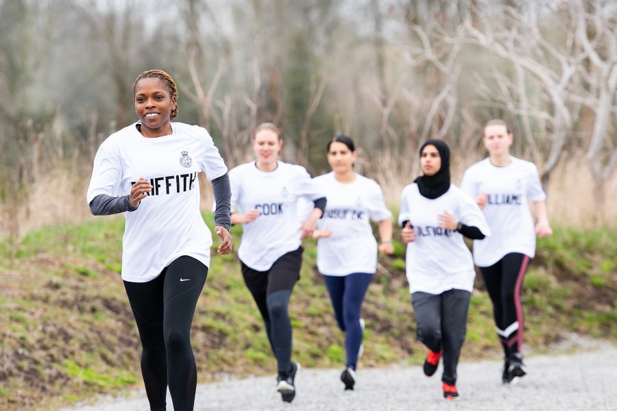 A group of police cadets running in the outdoors.