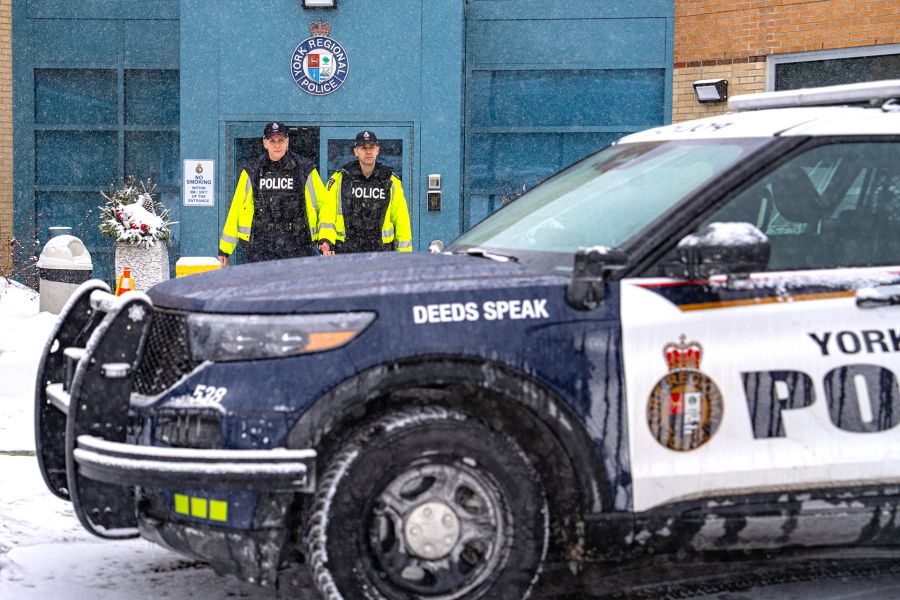 Two officers walk towards a cruiser in the snow