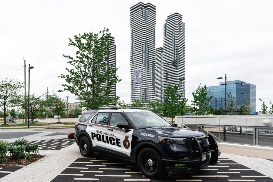 A police vehicle in front of a high rise complex