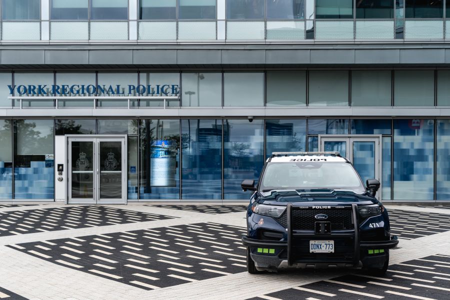 A police vehicle is parked in front of a building that reads YORK REGIONAL POLICE