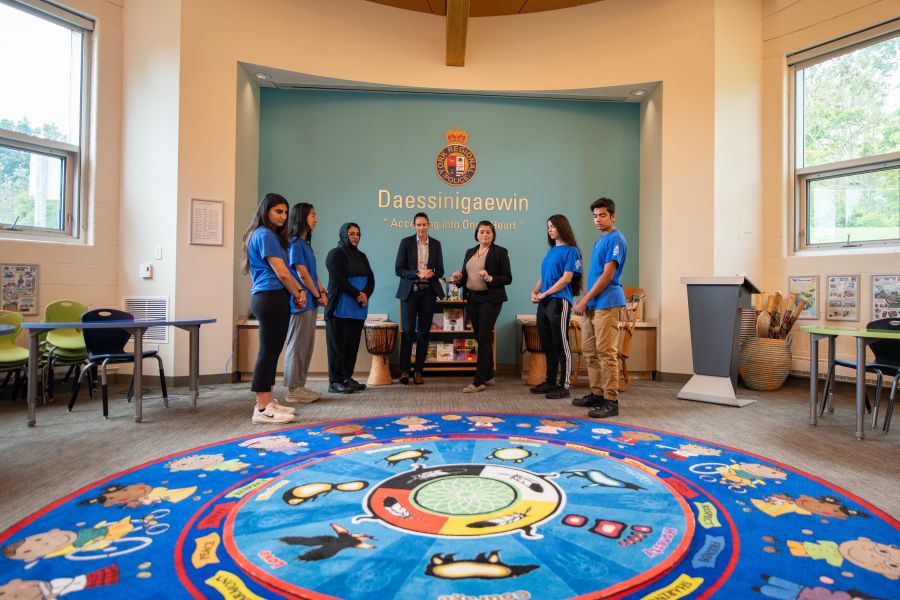 A group of people stand in a classroom