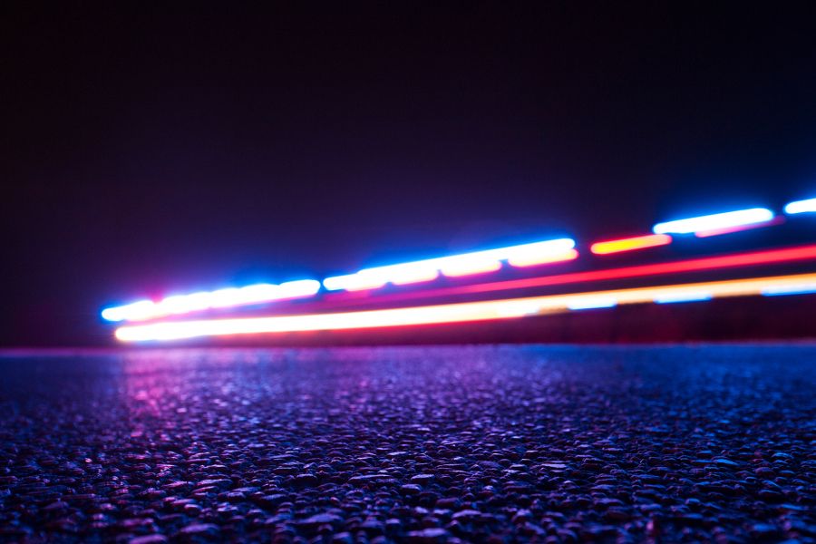 Colourful lights streak across the pavement