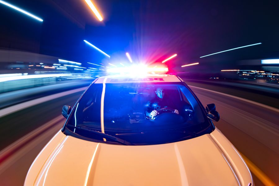 A police cruiser races through the night