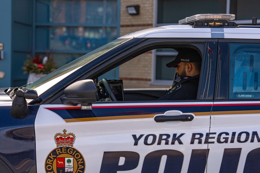 An officer types on a computer in a YRP cruiser.