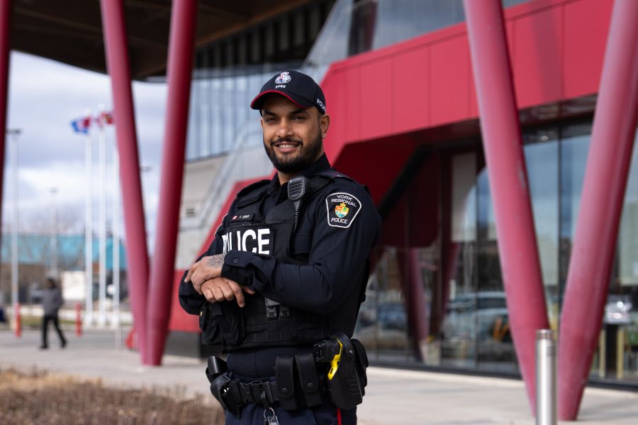 A police officer stands in front of a community center entrance