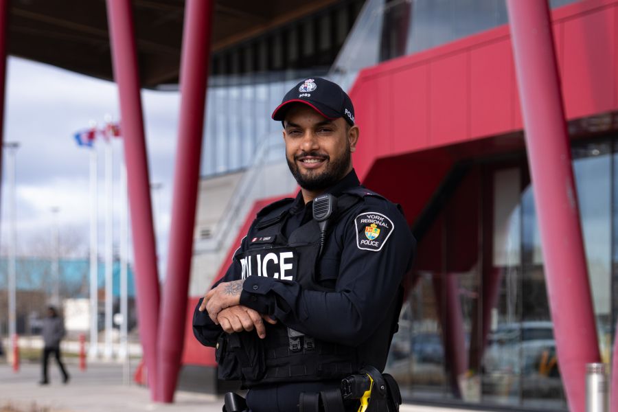A police officer stands in front of a community center entrance