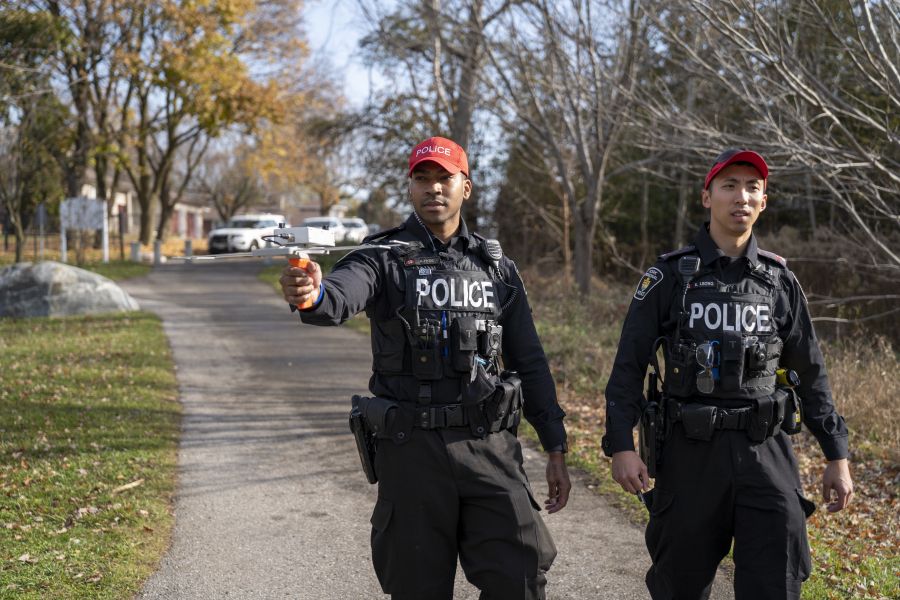 An officer holds a radio device on a path