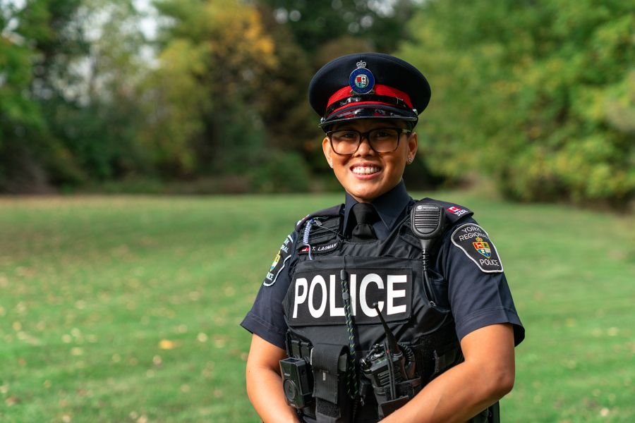 A female officer smiles in a photo outdoors.