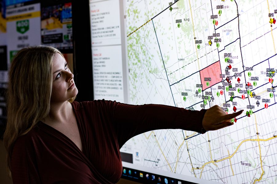 A woman points at a map on a screen