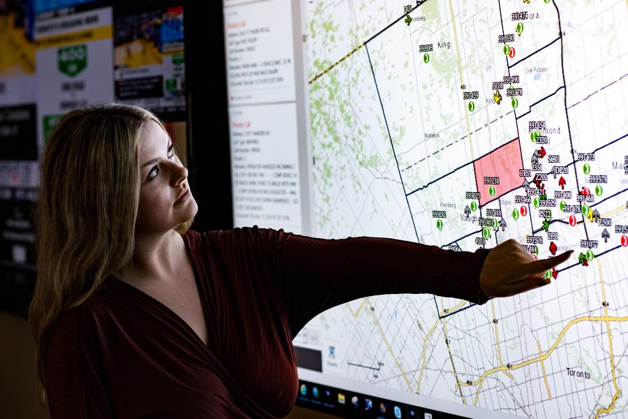 A woman points at a map on a screen