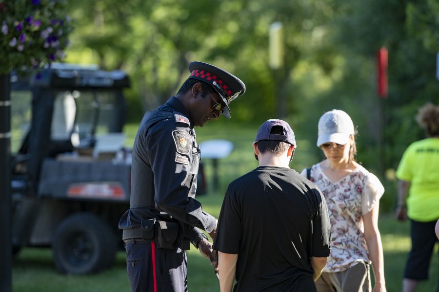 A man in a uniform stands with two others