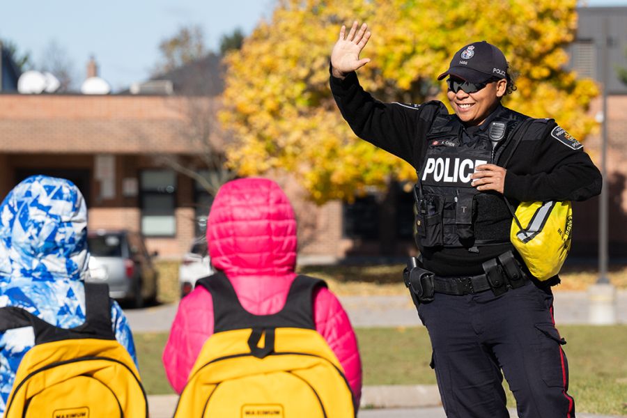 A woman in a police uniform raises a high five