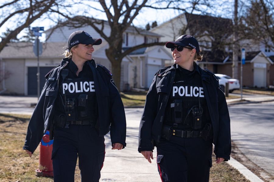 Two female officers walk in a neighbourhood.