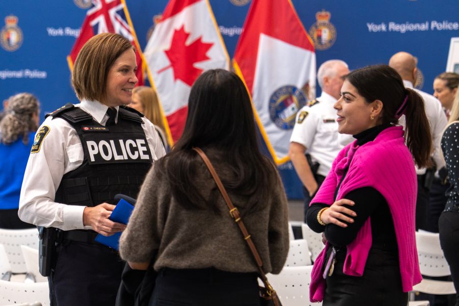 A group of women, one in a police uniform talking and laughing.