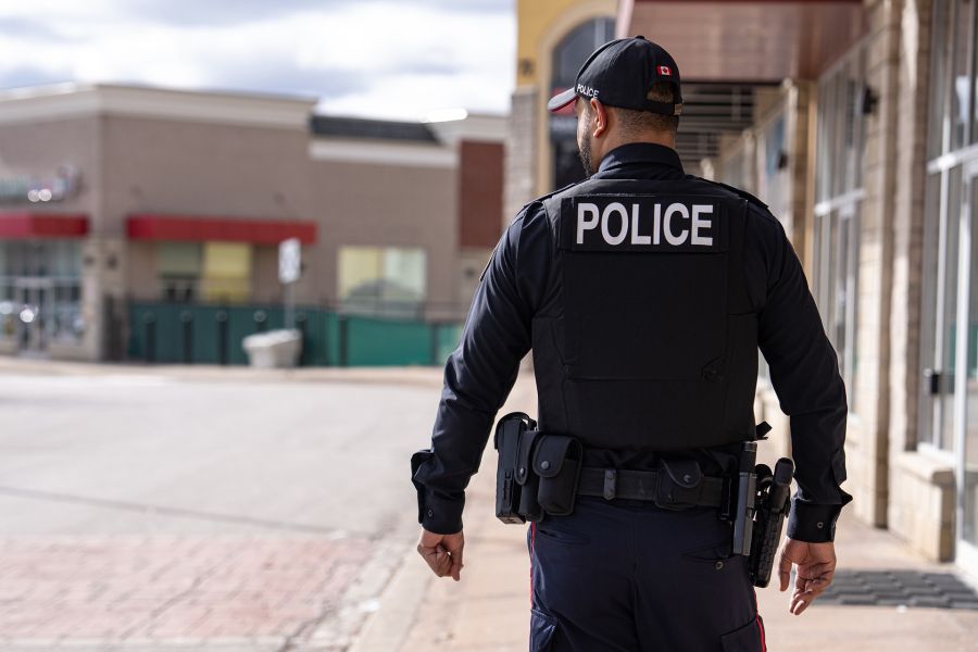 An officer walks by a business in a plaza