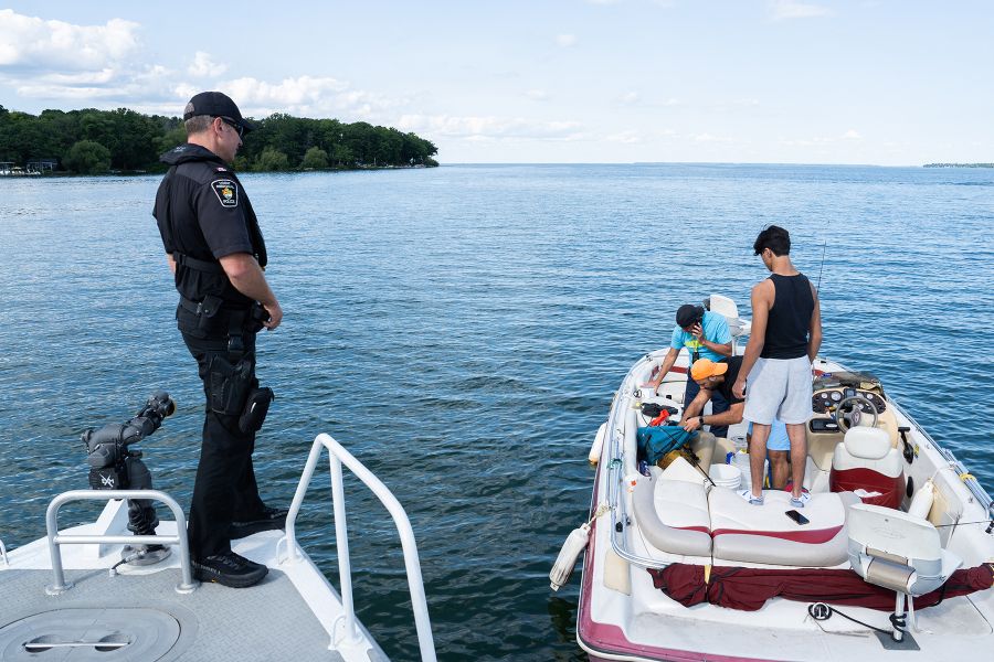 An officer speaks to a family on a boat
