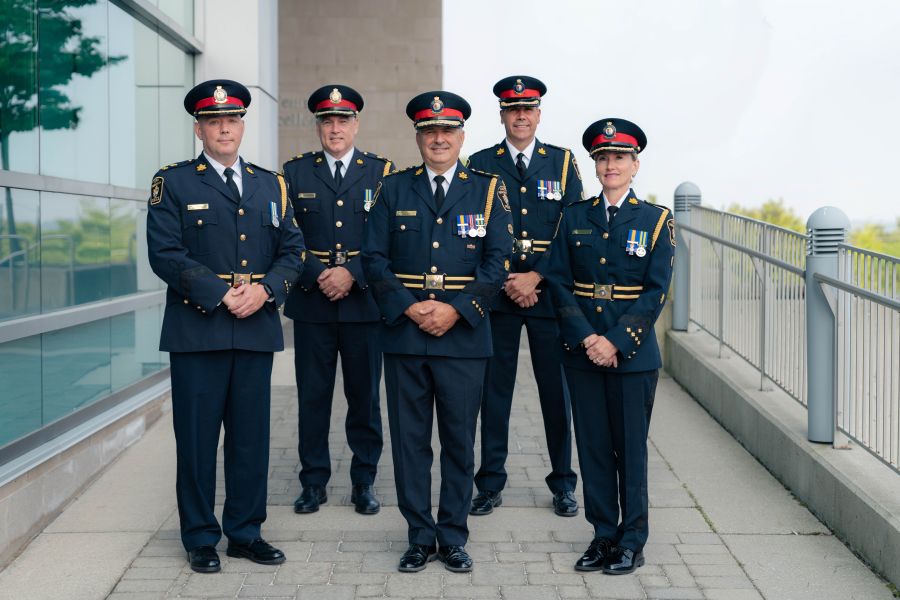 A group of five people in formal police uniforms