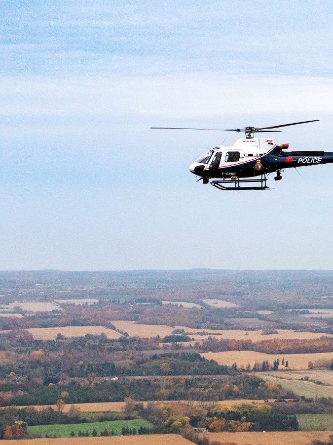 Police helicopter flying over farmers fields