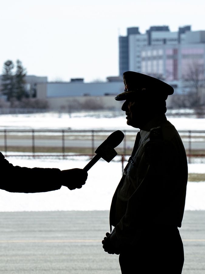A silhouette shows Chief MacSween speaking to a camera operator.