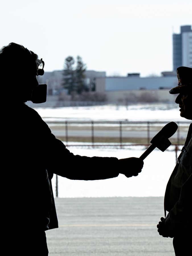 A silhouette shows Chief MacSween speaking to a camera operator.
