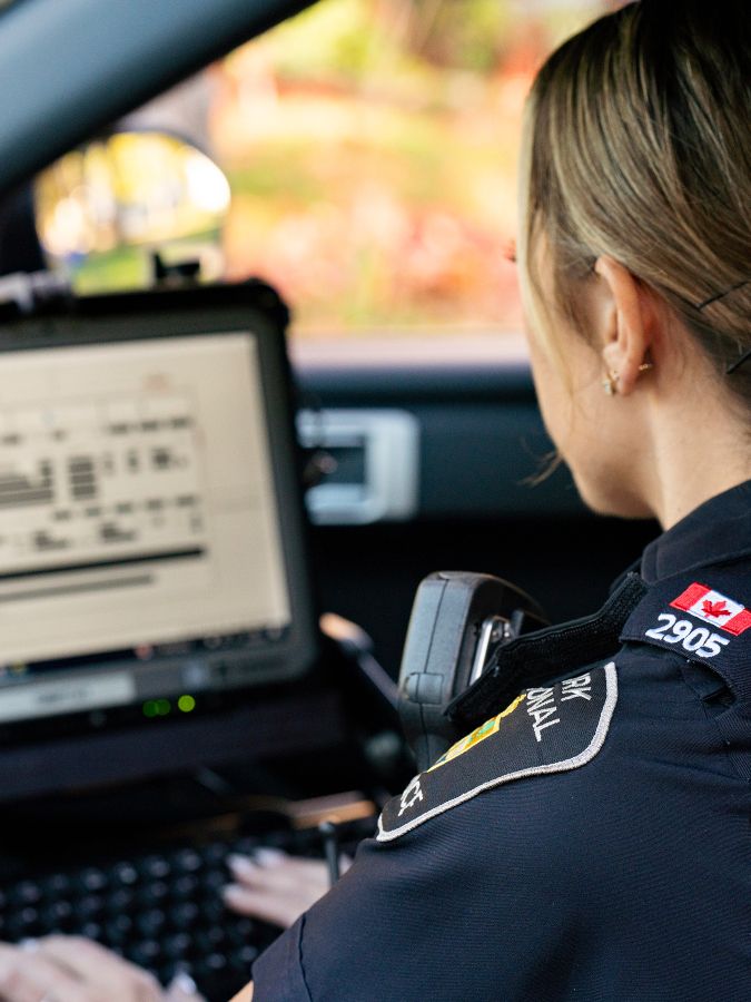 Police constable using an in car laptop