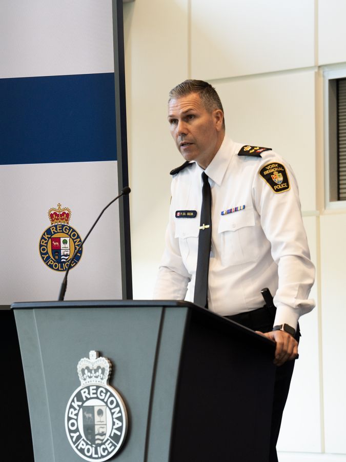 A man in a police uniform at a podium