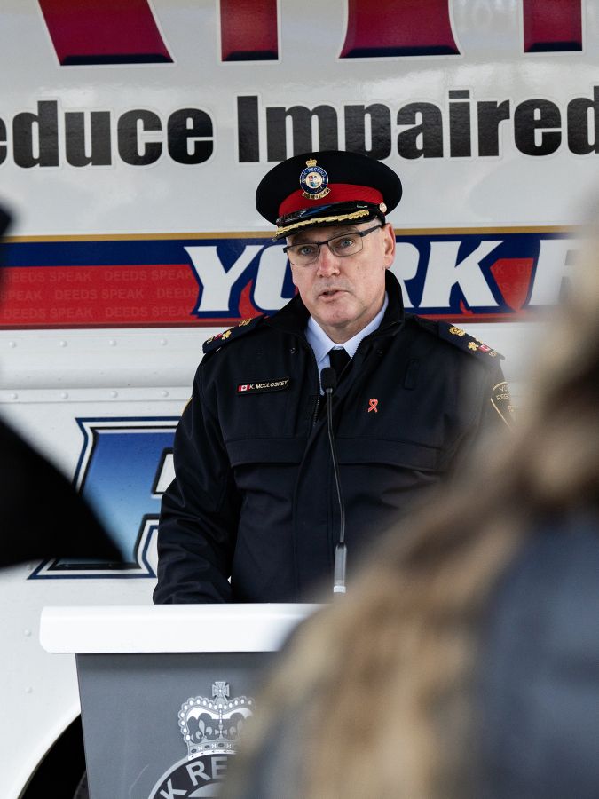 A man in a police uniform at a podium