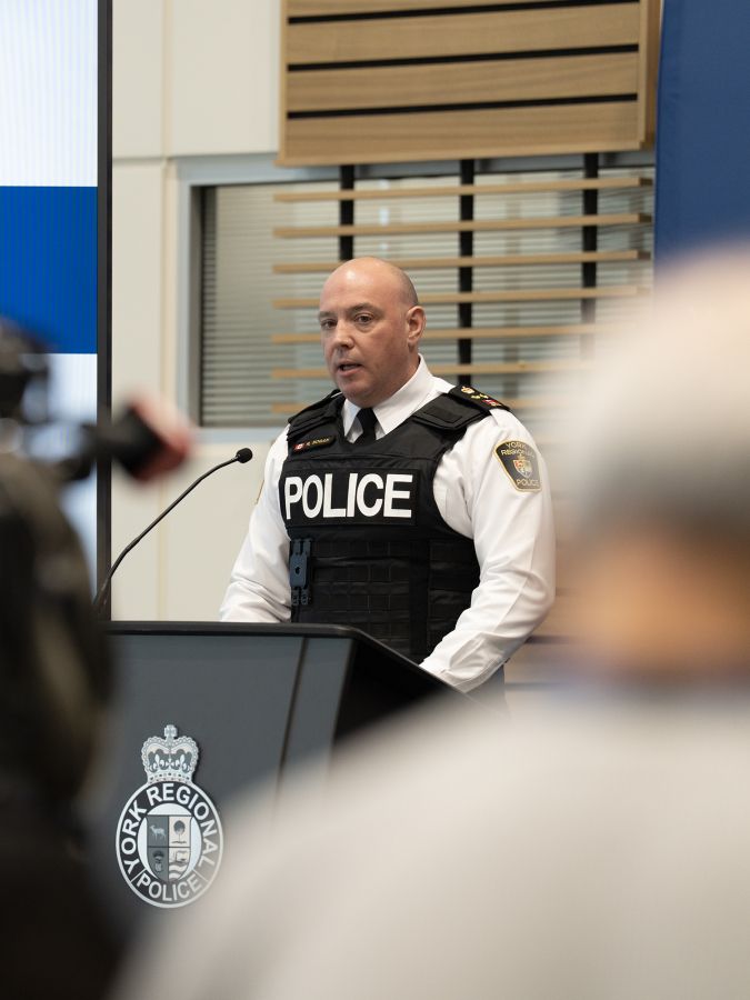 A man in a police uniform at a podium