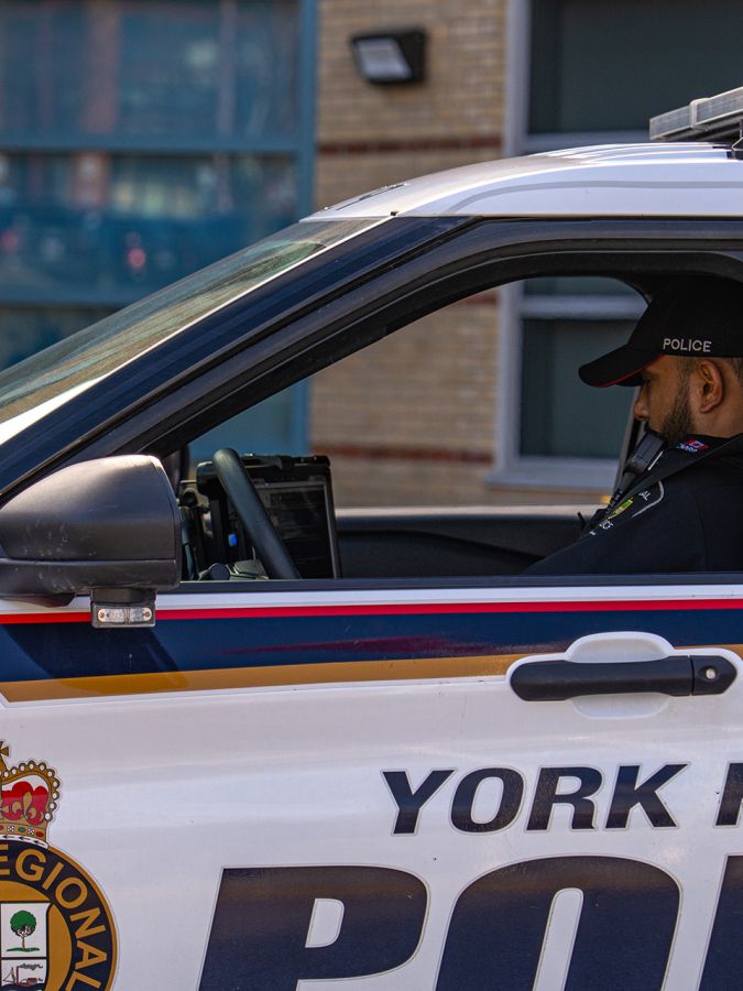 An officer types on a computer in a YRP cruiser.