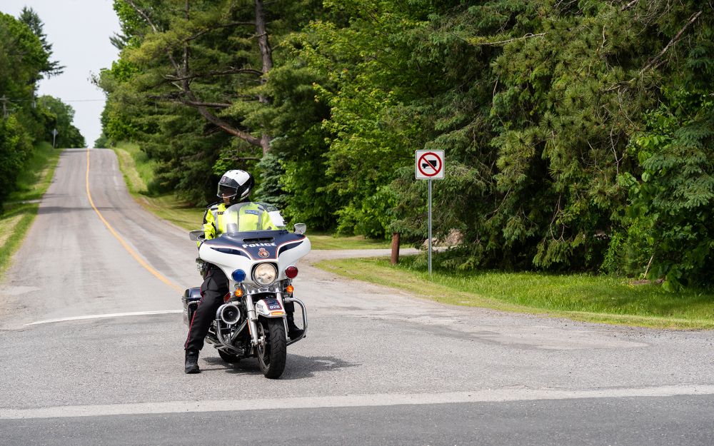An officer on a motorcyle looks at oncoming traffic before making a turn