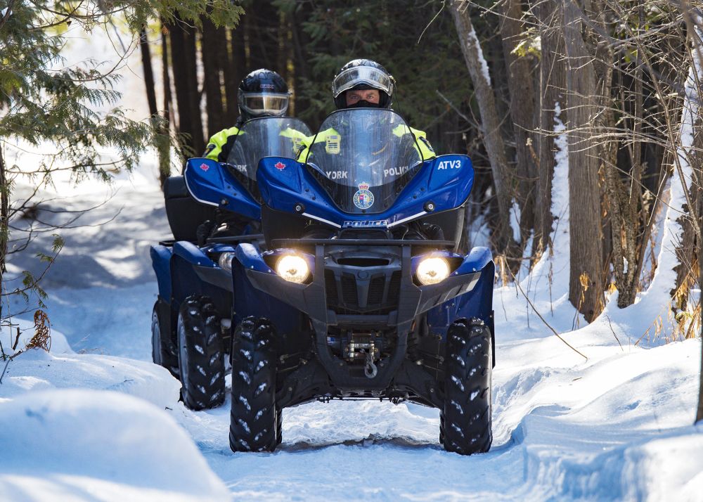 YRP officers drive two ATVs down a snowy path
