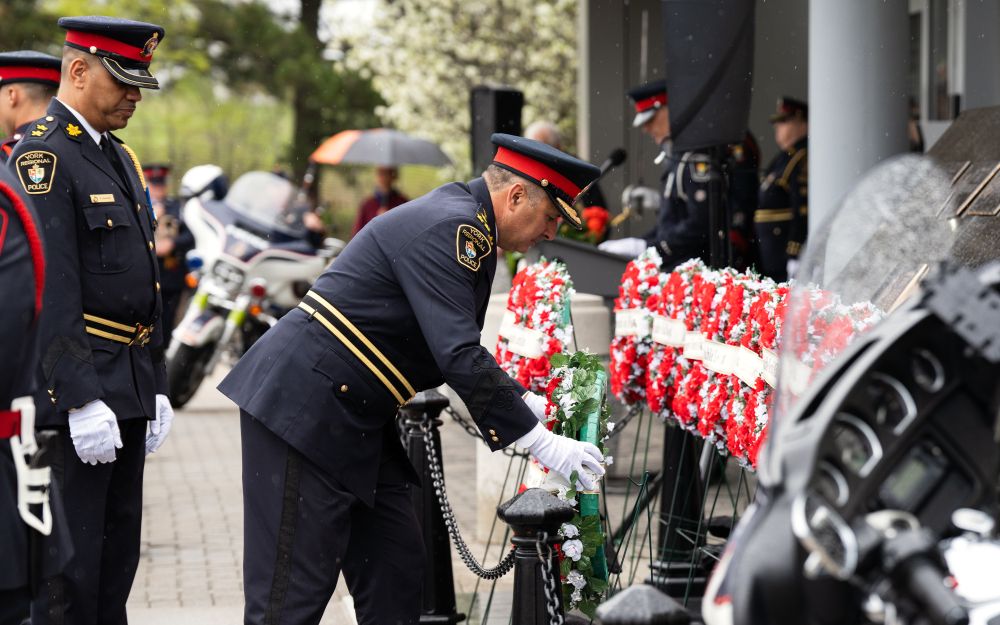A man lays a wreath down 