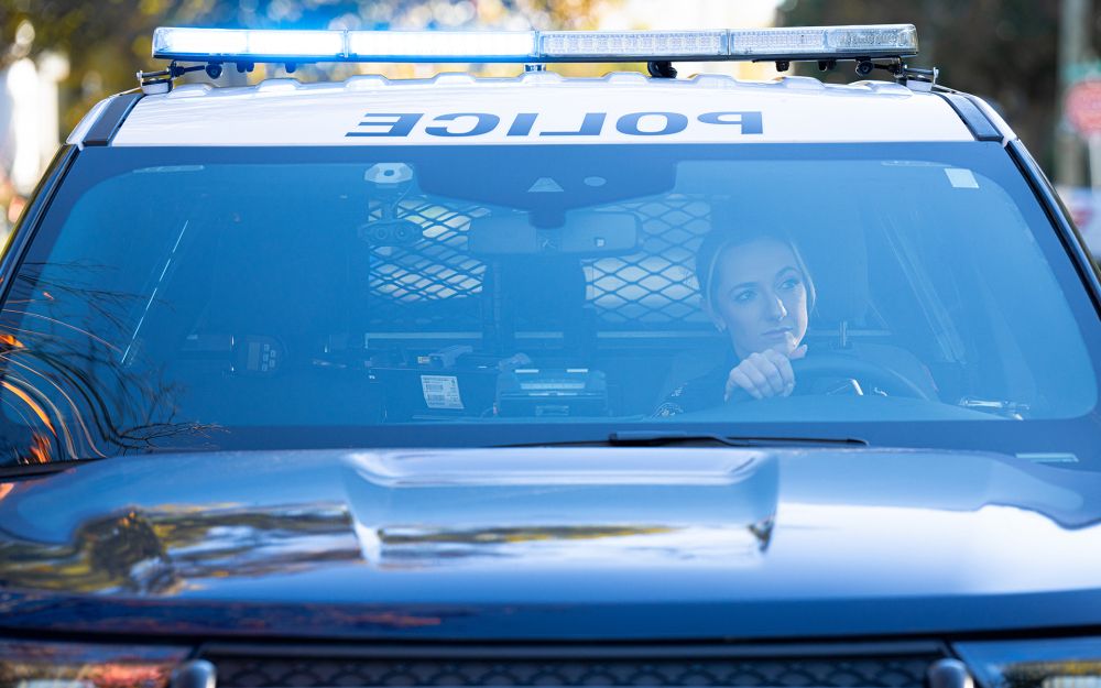 An officer can be seen behind the wheel of a cruiser