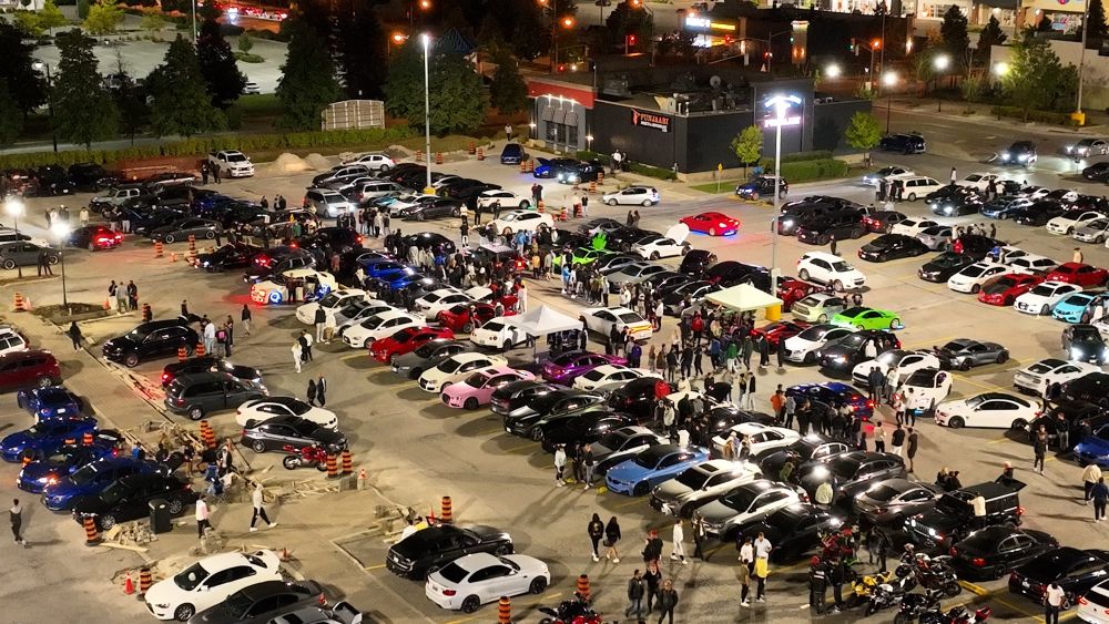 An aerial shot from Air2 shows a large car rally in a plaza parking lot