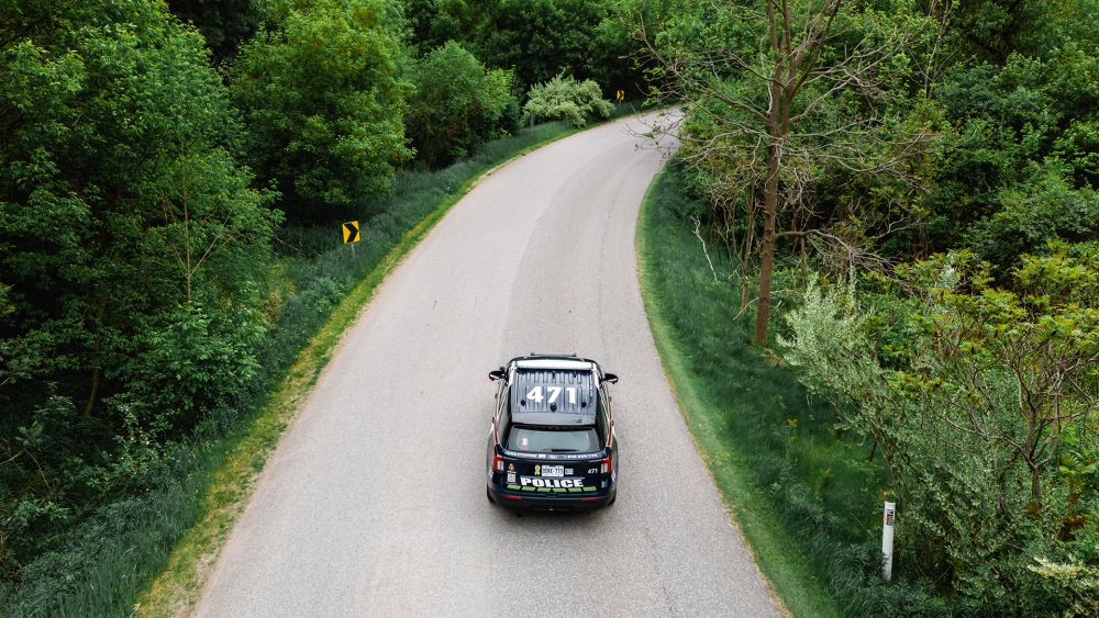 A cruiser drives down an empty road. 