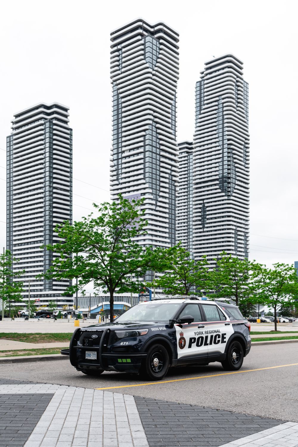 A police vehicle in front of a high rise complex 