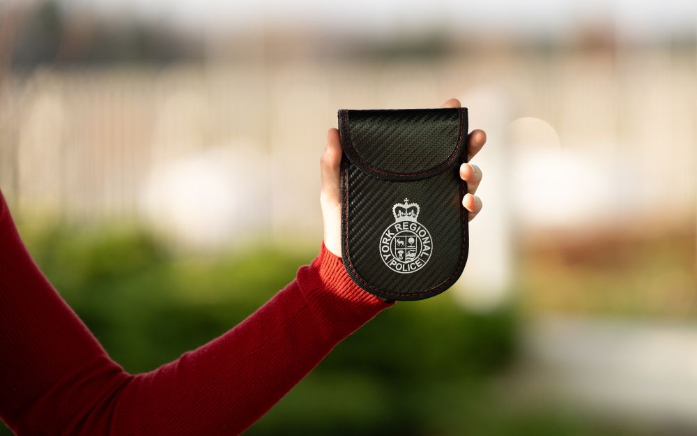 a hand holds a YRP branded Faraday bag