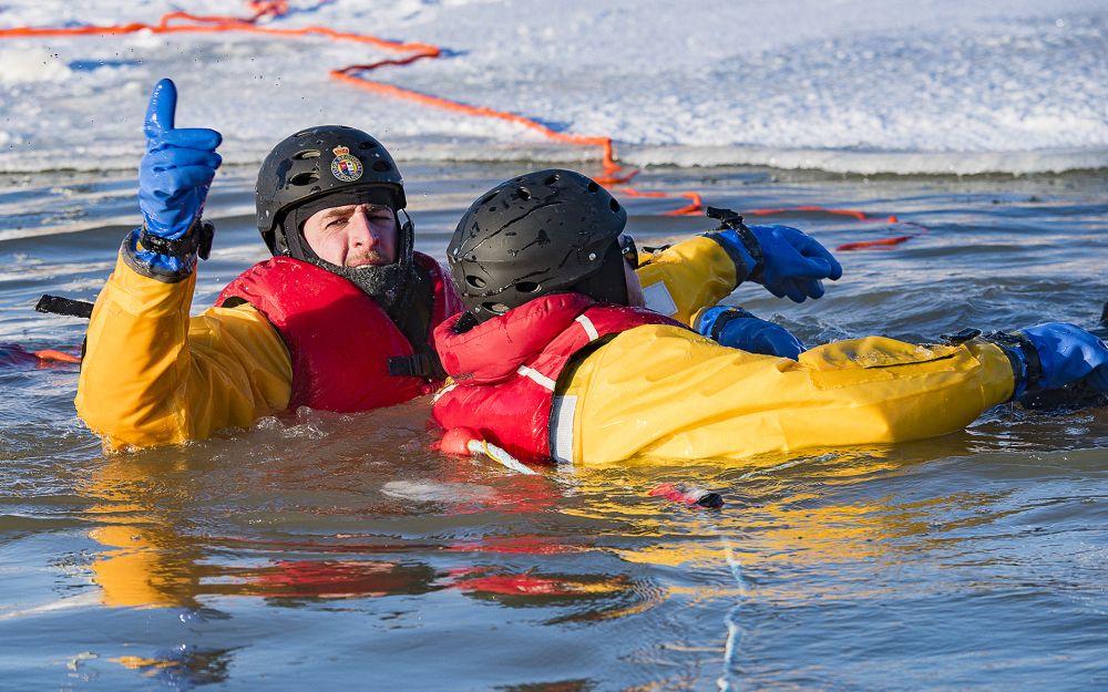 An officer rescues a person who has fallen through ice in a training exercise