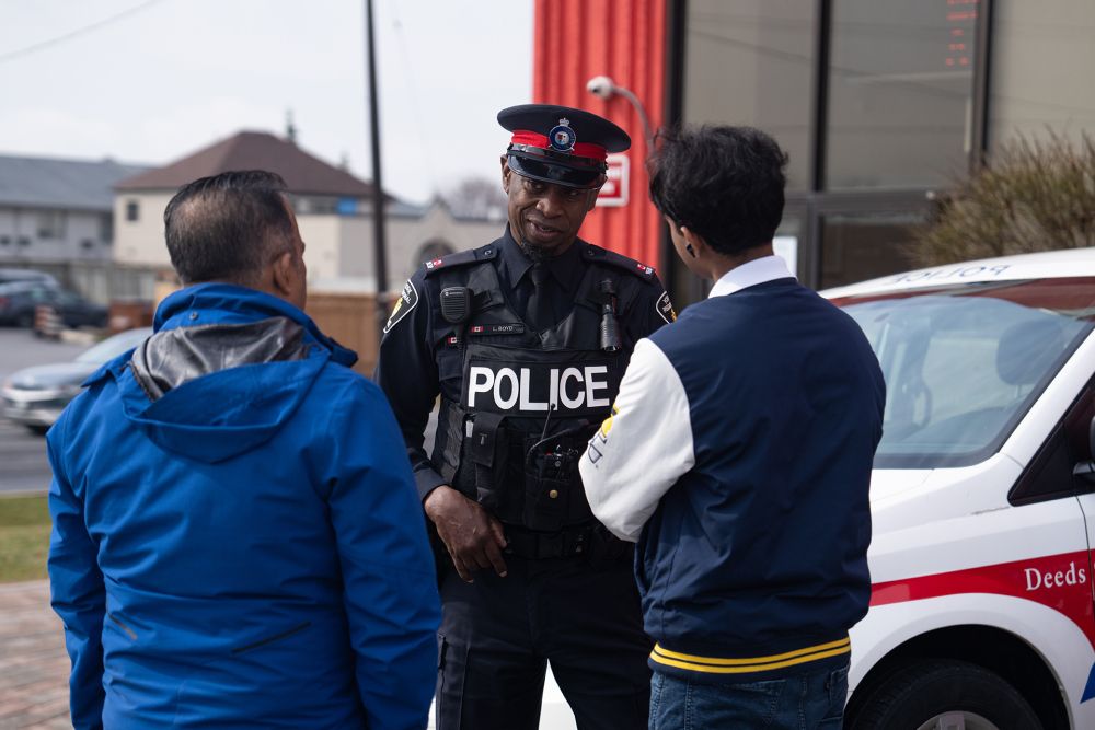 An officer speaks with a man and his teenage son