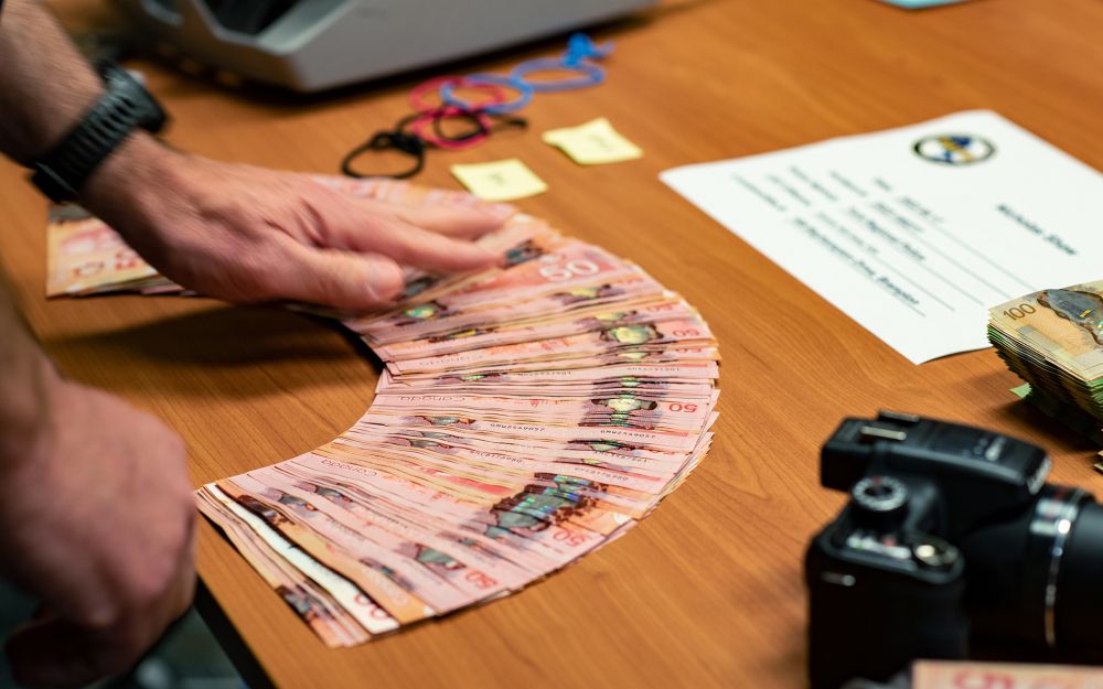 A table shows cash and other items seized. 