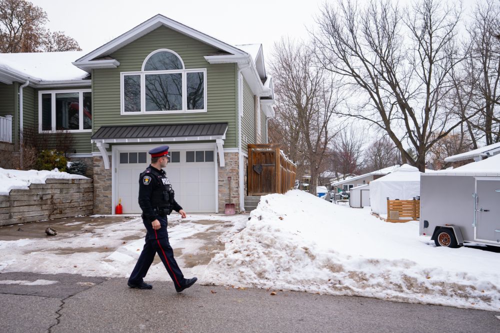 An officer walks by a home in a neighbourhood