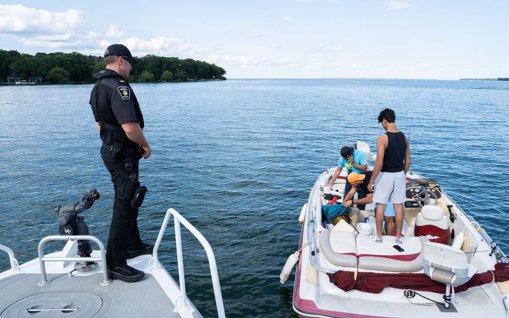 an officer on a YRP boat speaks to men on another boat